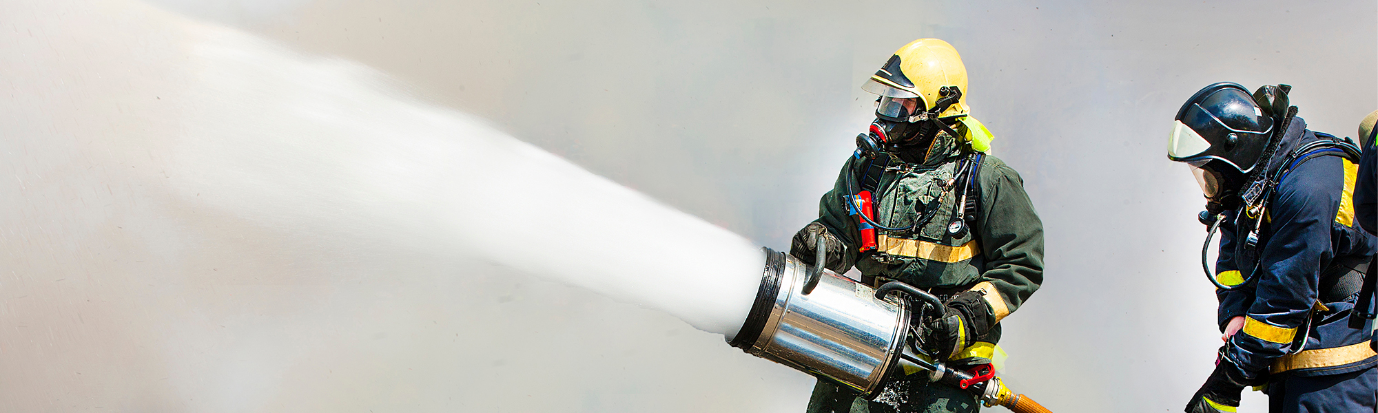 AdobeStock_87495059_hero Two firefighters using PFAS fire fighting foam to combat fire