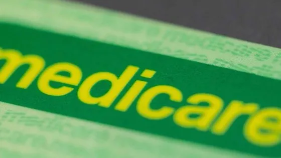 Close-up view of a green Medicare card with the word "medicare" prominently displayed in yellow.