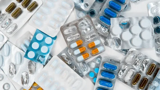 Assorted medications in various colored capsules and tablets, some packaged in blister packs.