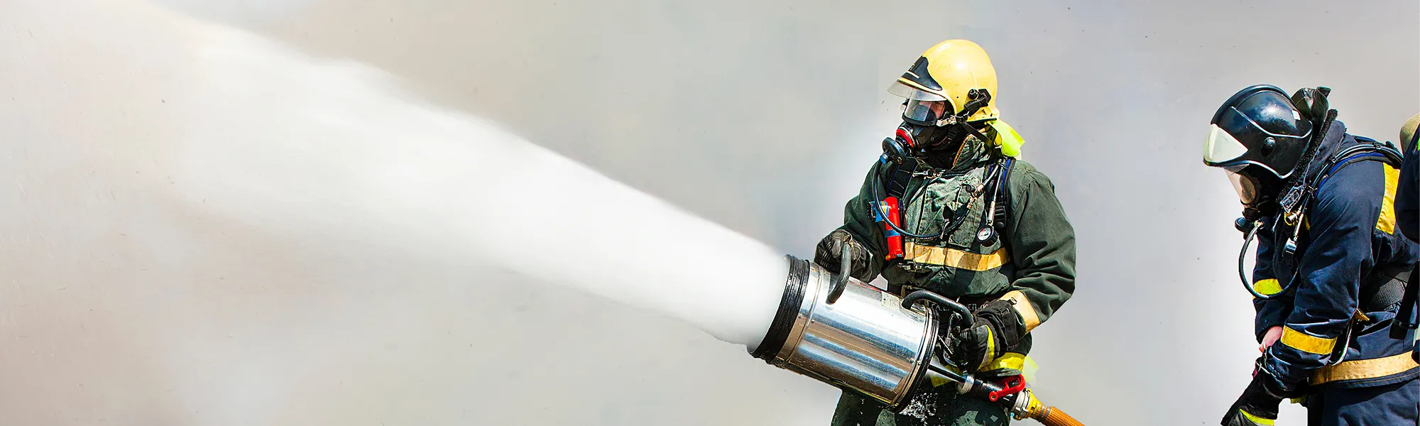 AdobeStock_87495059_hero Two firefighters using PFAS fire fighting foam to combat fire