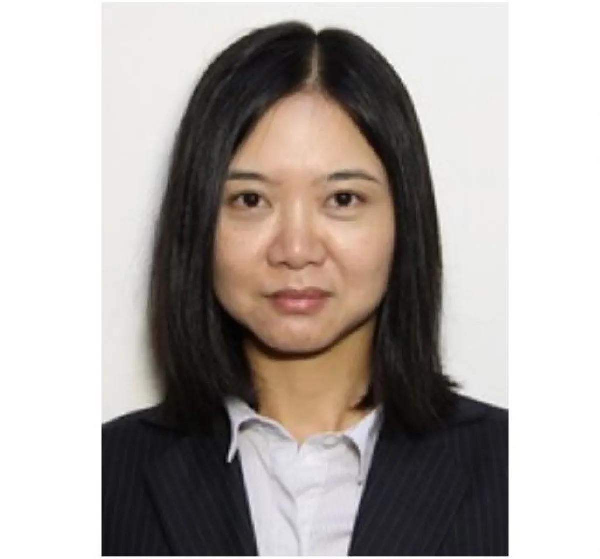 A portrait of a woman with shoulder-length straight black hair, wearing a dark striped suit jacket over a white shirt.