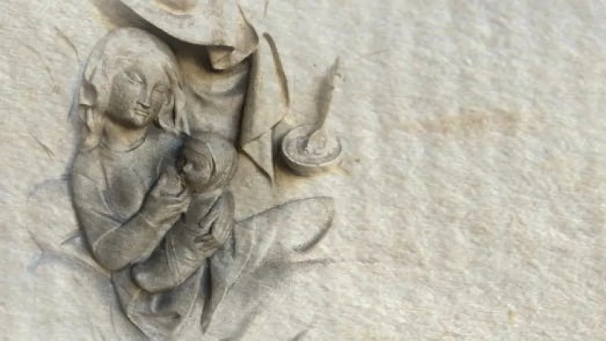 Stone carving of woman feeding baby