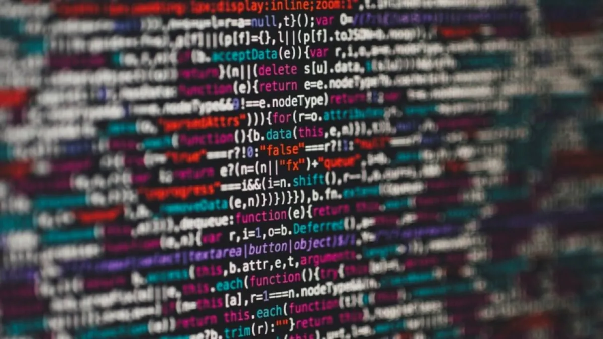 Focus of colorful, blurry lines of computer code fills the screen, suggesting the complexity and density of programming work.