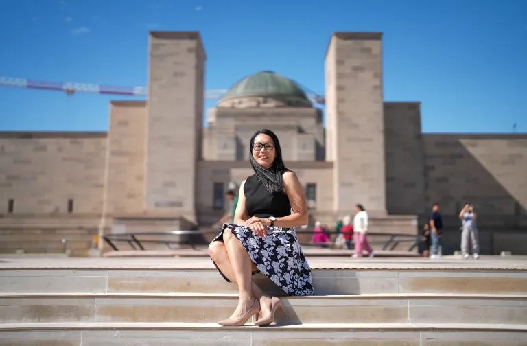 PhD student Col Maureen Montalban sitting in the forecourt of the Australian War Memorial. Photo: Tracey Nearmy